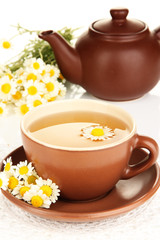 Cup of herbal tea with camomiles close up