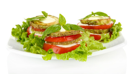Tasty roasted marrow and tomato slices with salad leaves,