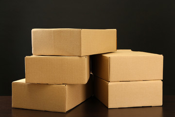 Parcels boxes on wooden table, on black background