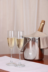 Champagne and glasses on round table on cloth background