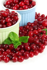 Ripe red cranberries in bowls, isolated on white.