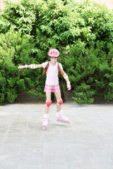 Obraz premium Little girl in roller skates at park