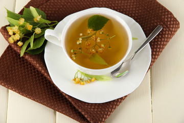 Cup of tea with linden on napkin on   wooden table