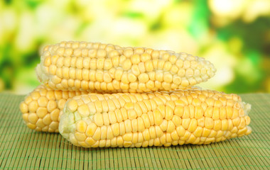 Fresh corn on bamboo mat, on bright background