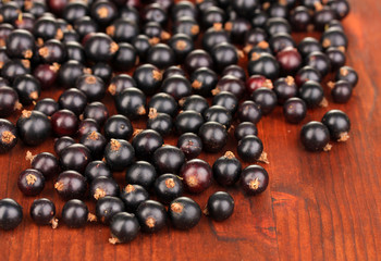Fresh black currant on wooden background
