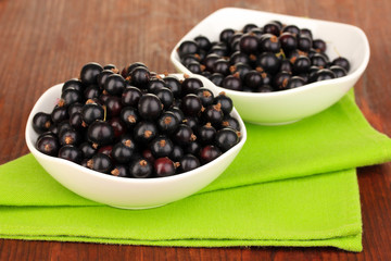 Fresh black currant on wooden background