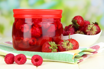 Home made berry jam on wooden table on bright background