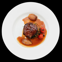 Tenderloin steak in plate, isolated on black