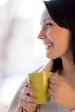 Woman drinking coffee. Beautiful middle-aged woman standing in f