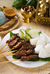 Thai chicken skewers with lime and chili, on wooden board.