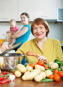 Mature woman cooking veggie lunch in kitchen