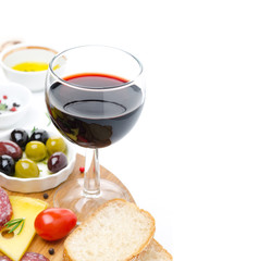 glass of red wine and appetizers - cheese, bread, salami, olives