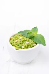 Tischdecke close-up of green pea pesto with mint on a white background © cook_inspire