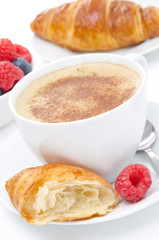 cup of cappuccino and fresh croissant, raspberry for breakfast