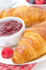 breakfast - fresh croissant with raspberry jam, close-up