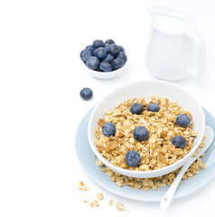 homemade granola, blueberries and jug of milk, isolated on white