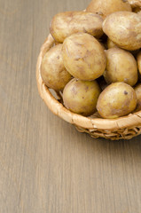 Fototapeta na wymiar potatoes in a basket on a gray wooden background