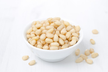 pine nuts in a bowl on a white background