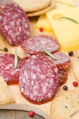 salami, cheese and crackers on a cutting board, closeup