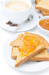 toast with orange jam and cup of cappuccino for breakfast