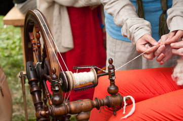 spinningwheel with hands making yarn from the wool