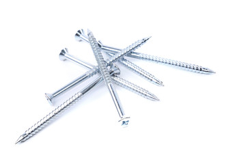 Random pile of threaded steel screws on white