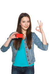 Young teen female showing blank credit card and gesturing OK