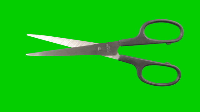 Real scissors animated on a green background