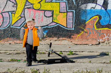 Obraz premium Cute little boy playing in front of graffiti