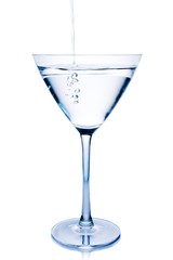 filling a  white cocktail in a glass with blue reflections