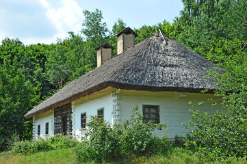 Fototapeta na wymiar Ancient traditional ukrainian rural cottage with a straw roof