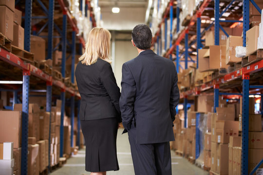 Rear View Of Businesswoman And Businessman In Warehouse