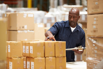 Worker In Warehouse Preparing Goods For Dispatch - Powered by Adobe