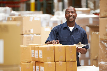 Worker In Warehouse Preparing Goods For Dispatch