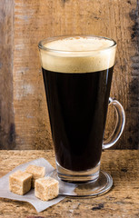 High glass cup espresso coffee with cane cubes on old wooden rus