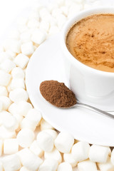 Closeup of cup of hot chocolate with marshmallows resting on whi