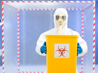 parson in protective suit holding biohazard waste