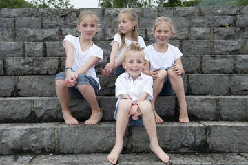 brothers and sisters, outdoors on stone stairs