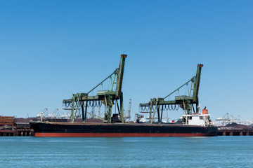 Fototapeta na wymiar Ship is unloading the iron ore