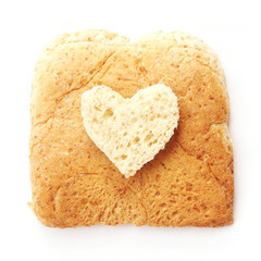Sliced whole wheat bread with heart shape on white background
