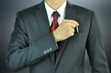 Businessman picking a pen from the pocket