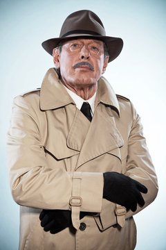 Retro detective man with mustache and hat. Wearing raincoat. Stu