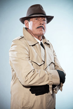 Retro detective man with mustache and hat. Wearing raincoat. Stu
