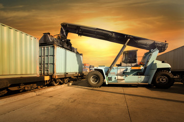 Crane lifting up container in sunset - 53660540