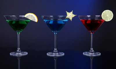 Alcoholic cocktails in martini glasses on dark blue background