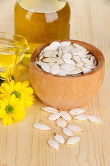 Useful pumpkin seed oil on wooden table close-up