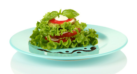 Tasty roasted marrow and tomato slices with salad leaves,