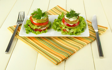 Tasty roasted marrow and tomato slices with salad leaves,