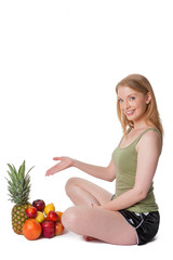 Cross-legged happy young woman shows mixed fruit