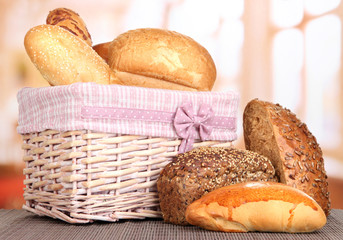 Baked bread in wicker basket on window background